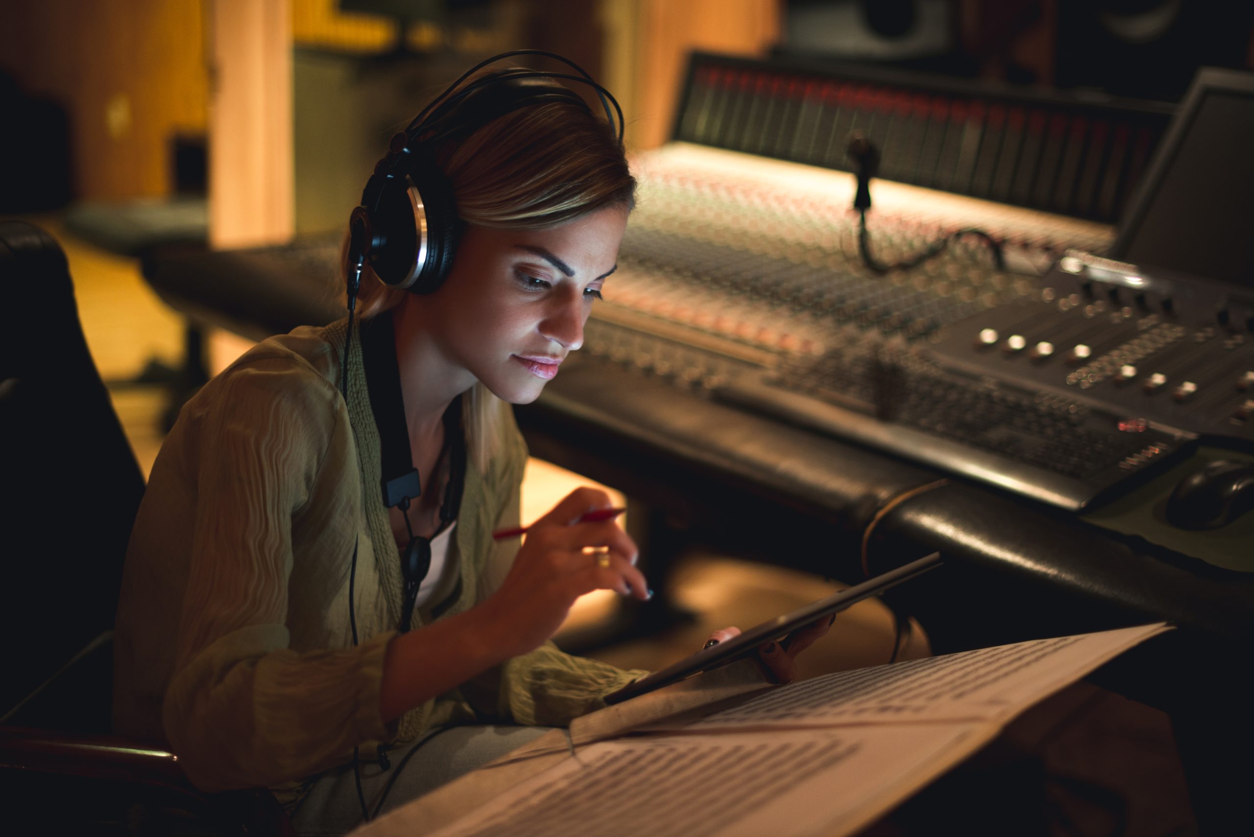 Junge Musikerin, die in einem Musikstudio ihren nächsten Song schreibt.